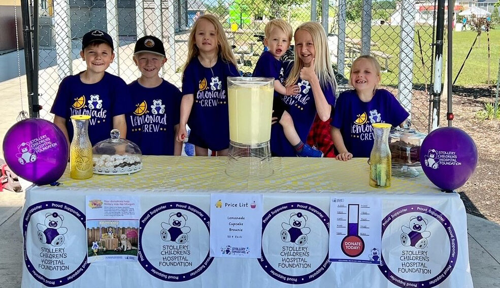 group of kids selling lemonade at a table