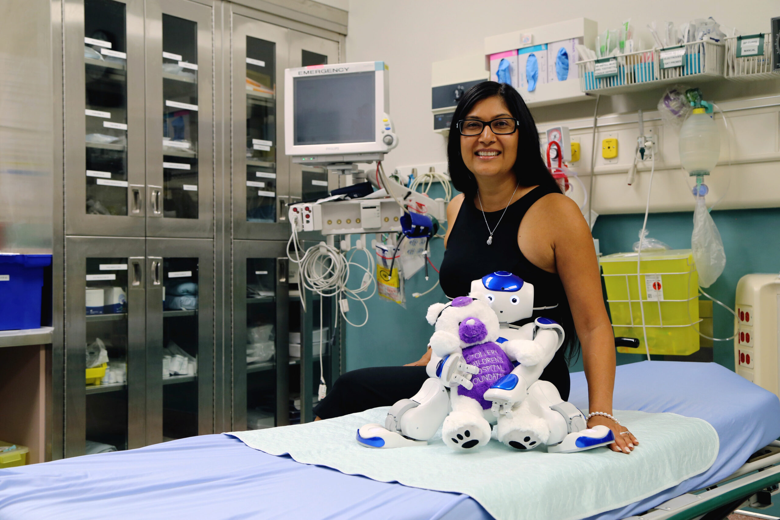 stollery doc with medi robot sitting on hospital bed