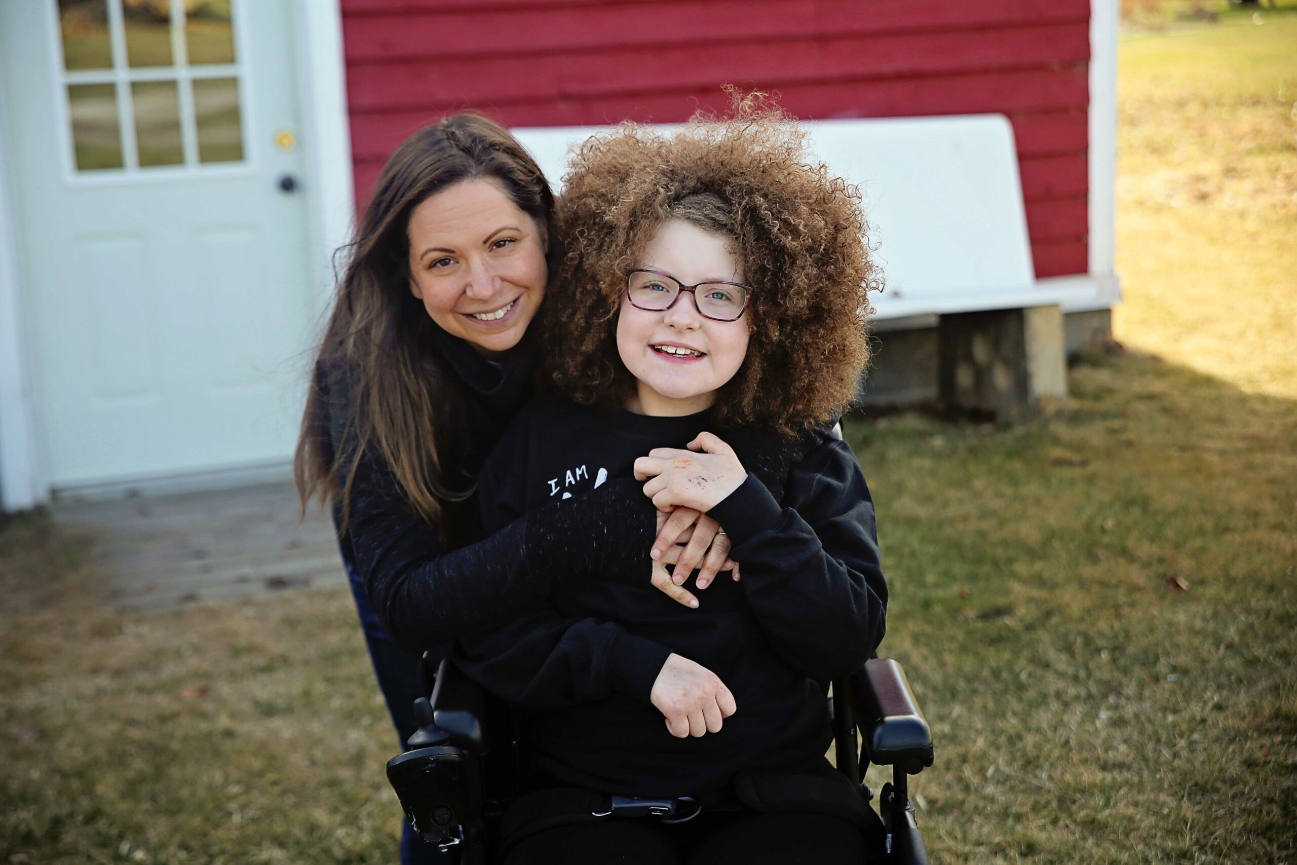 stollery kid jordan and her mom smiling outside on the grass