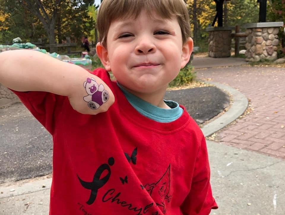 kid showing bear tattoo outside at event