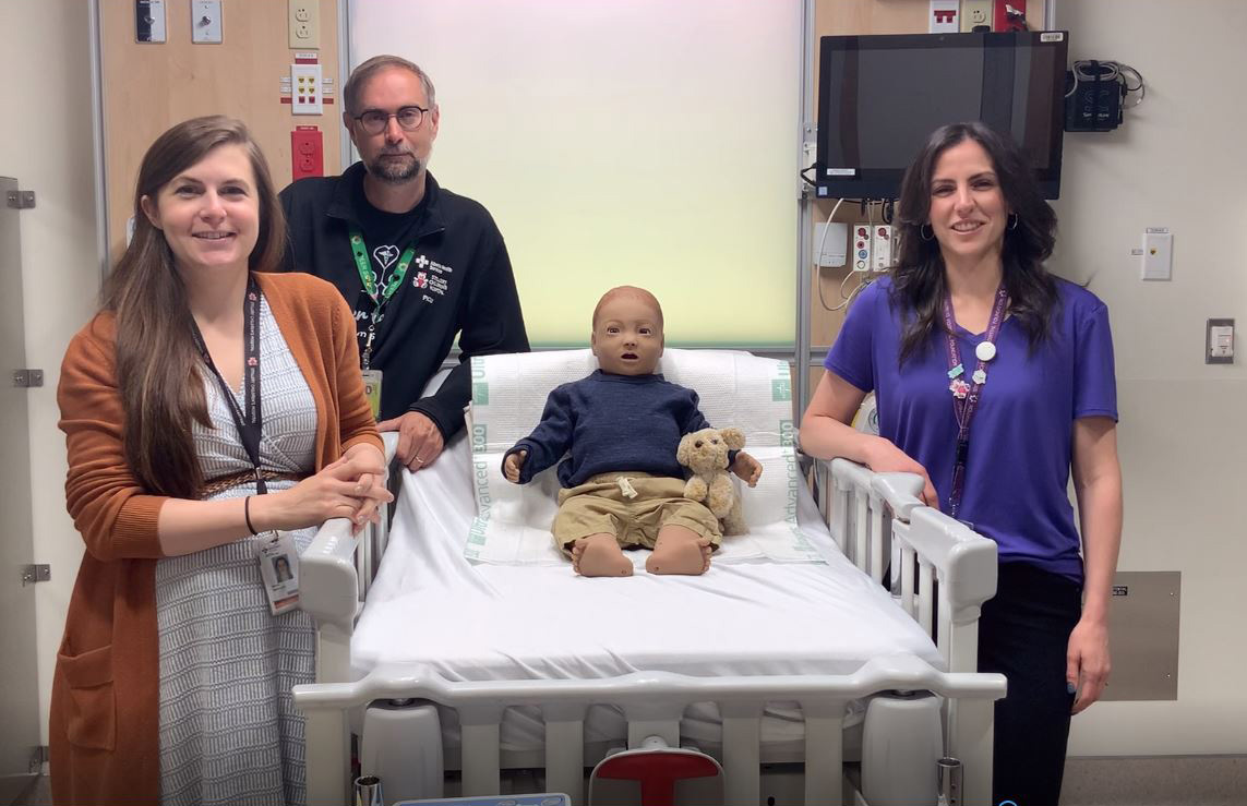 stollery simulation program team with sim baby sitting on bed