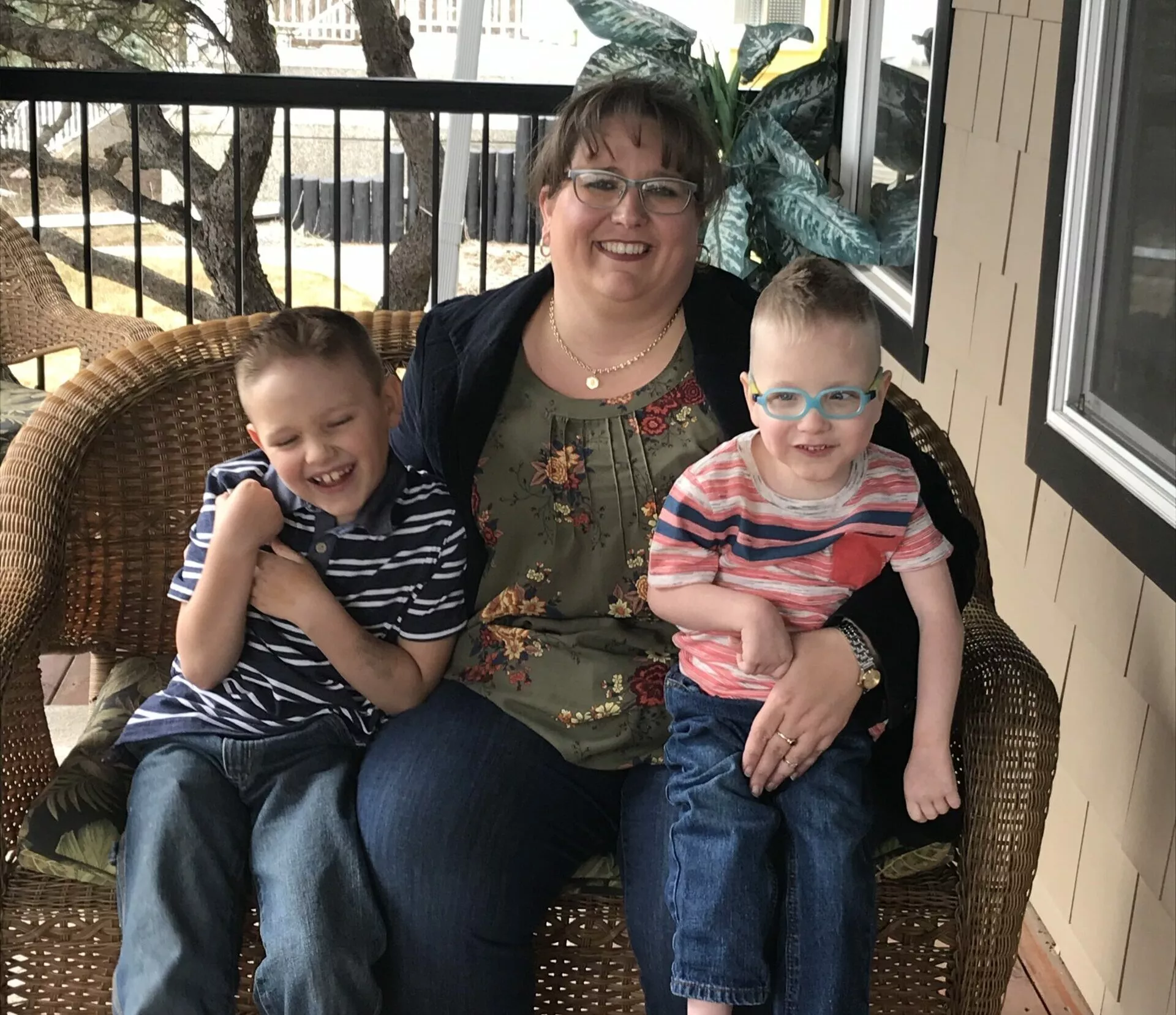 stollery kid cameron with brother and mom sitting on front porch bench