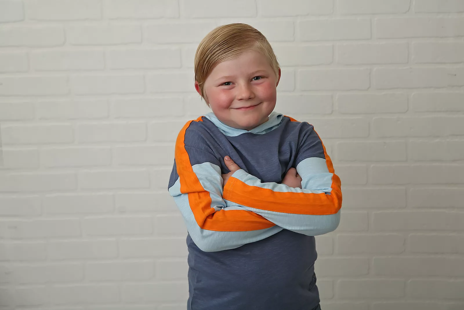 stollery kid tucker arms crossed against brick wall